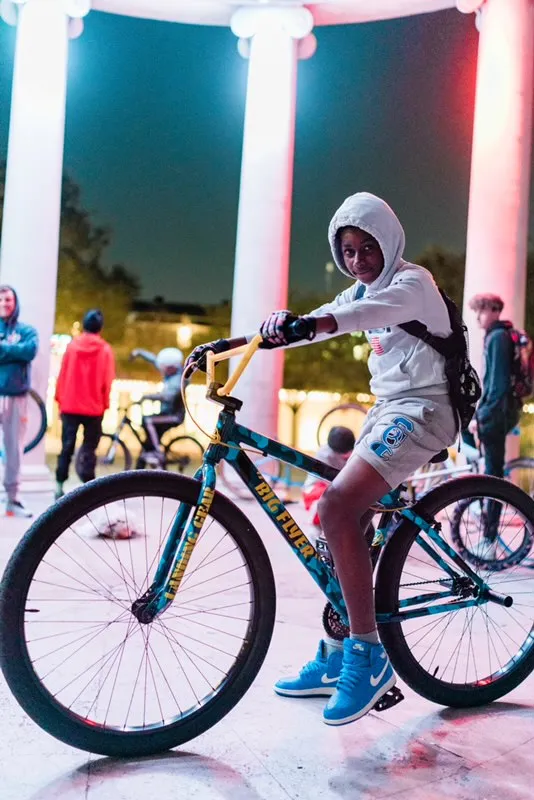 Rider on a SE Big Flyer bike under lit columns at night